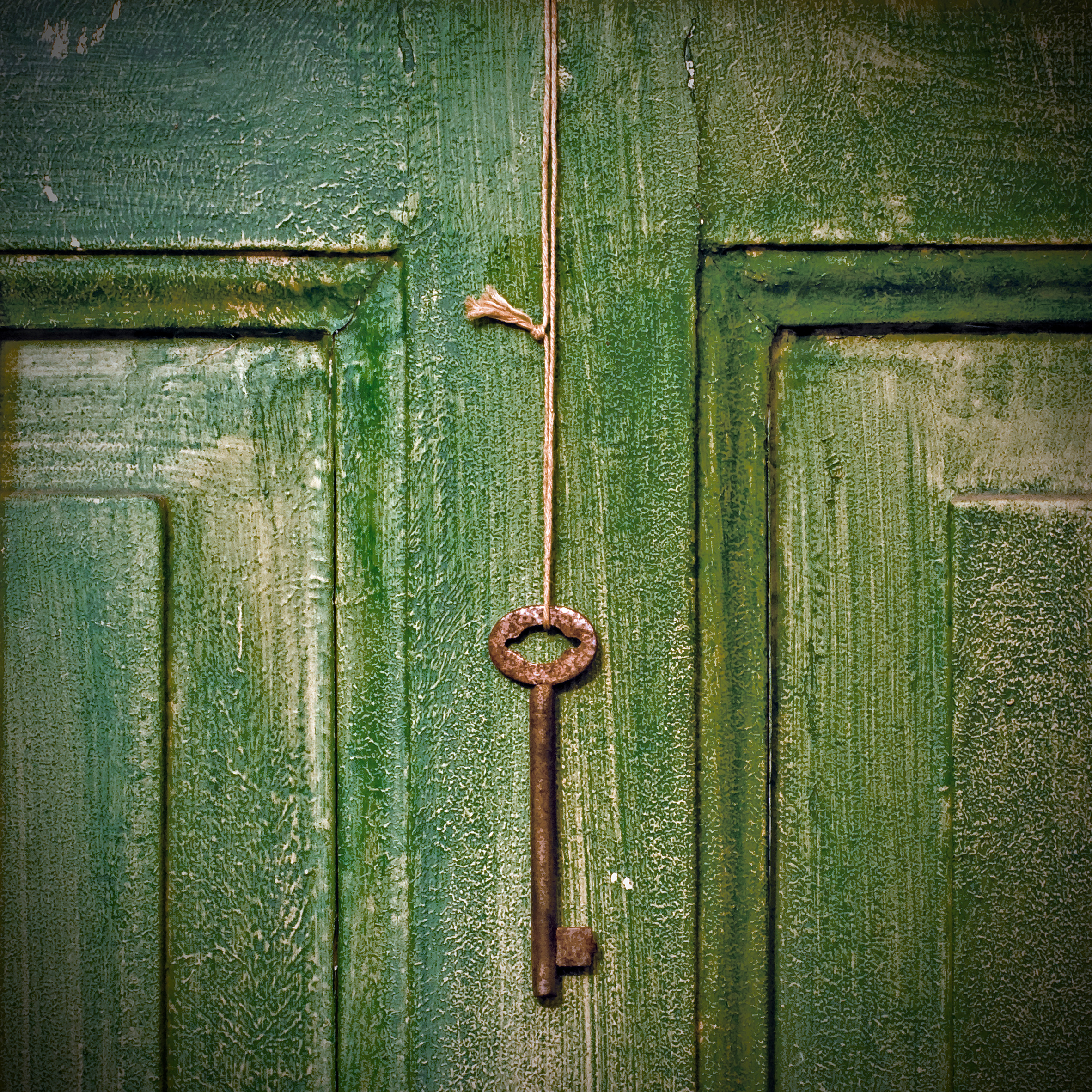 Old key hanging on wooden door